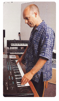 (photo of Eno playing his DX7)